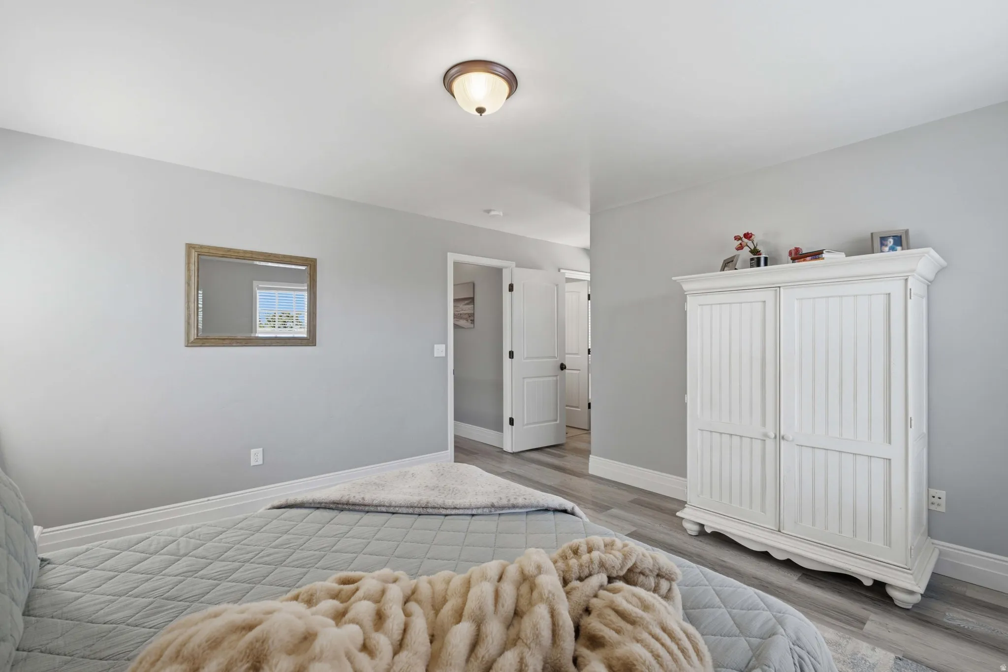 Owners suite has neutral-toned walls, wood-finish flooring, and a ceiling-mounted light fixture