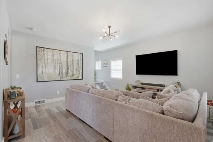 Wood-finish flooring, light gray wall tones, recessed lighting, and a modern ceiling light fixture