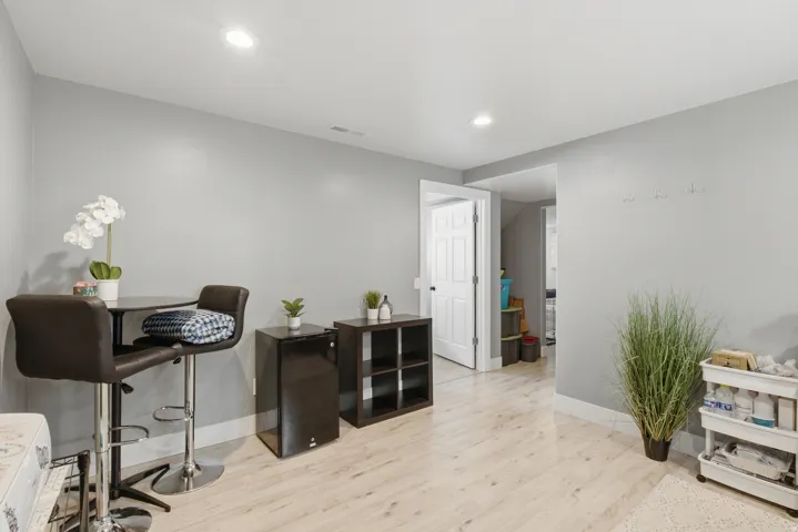 A second living room space that also can be used as an office, play area, or work out room. Light wood-finish flooring with recessed lighting and neutral wall tones