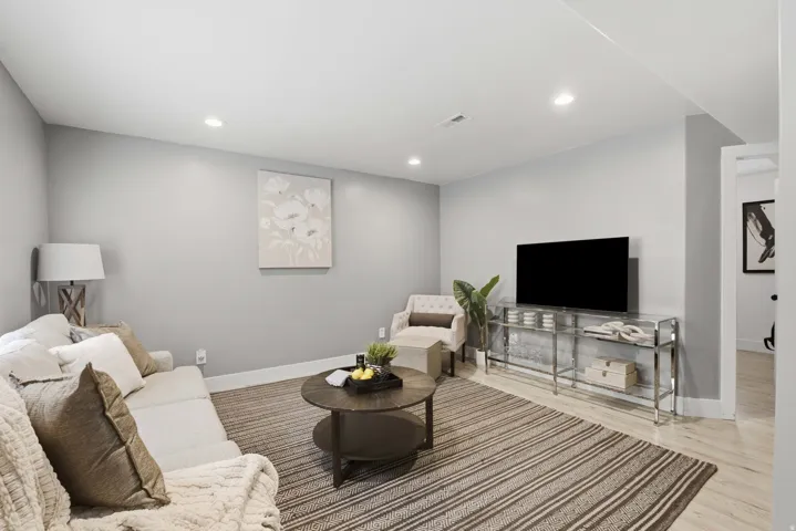 Recessed lighting, light wood-finish flooring, white trim, light gray walls, and an open doorway