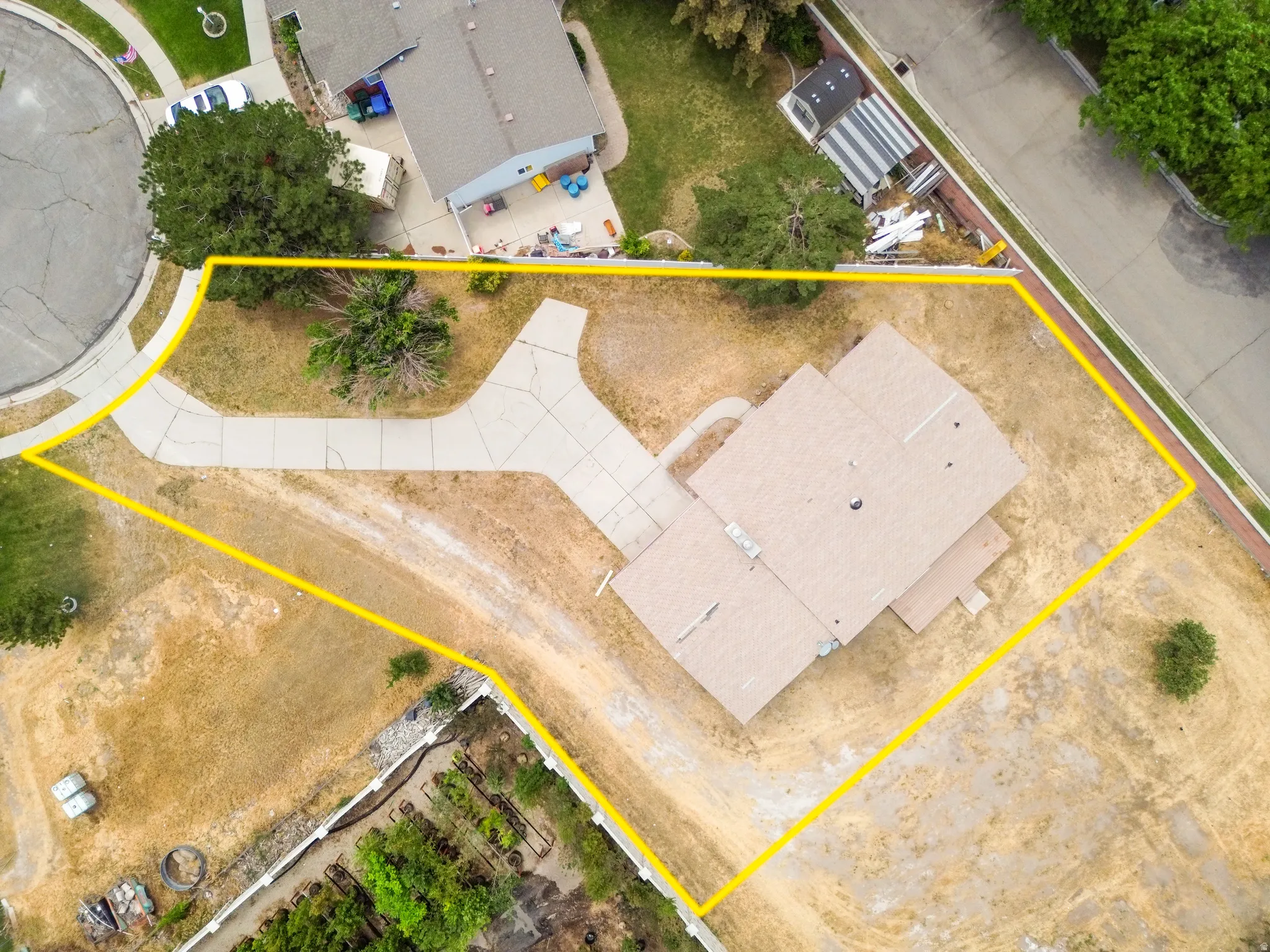 Extensive lot featuring a paved driveway, mature trees, and a cul-de-sac location