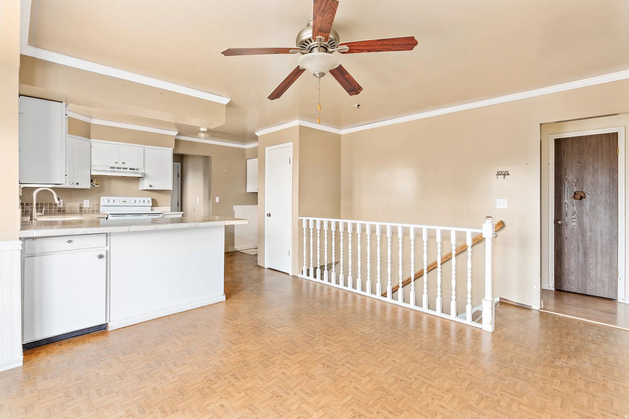 Kitchen with white cabinetry, a built-in dishwasher, and an integrated breakfast bar