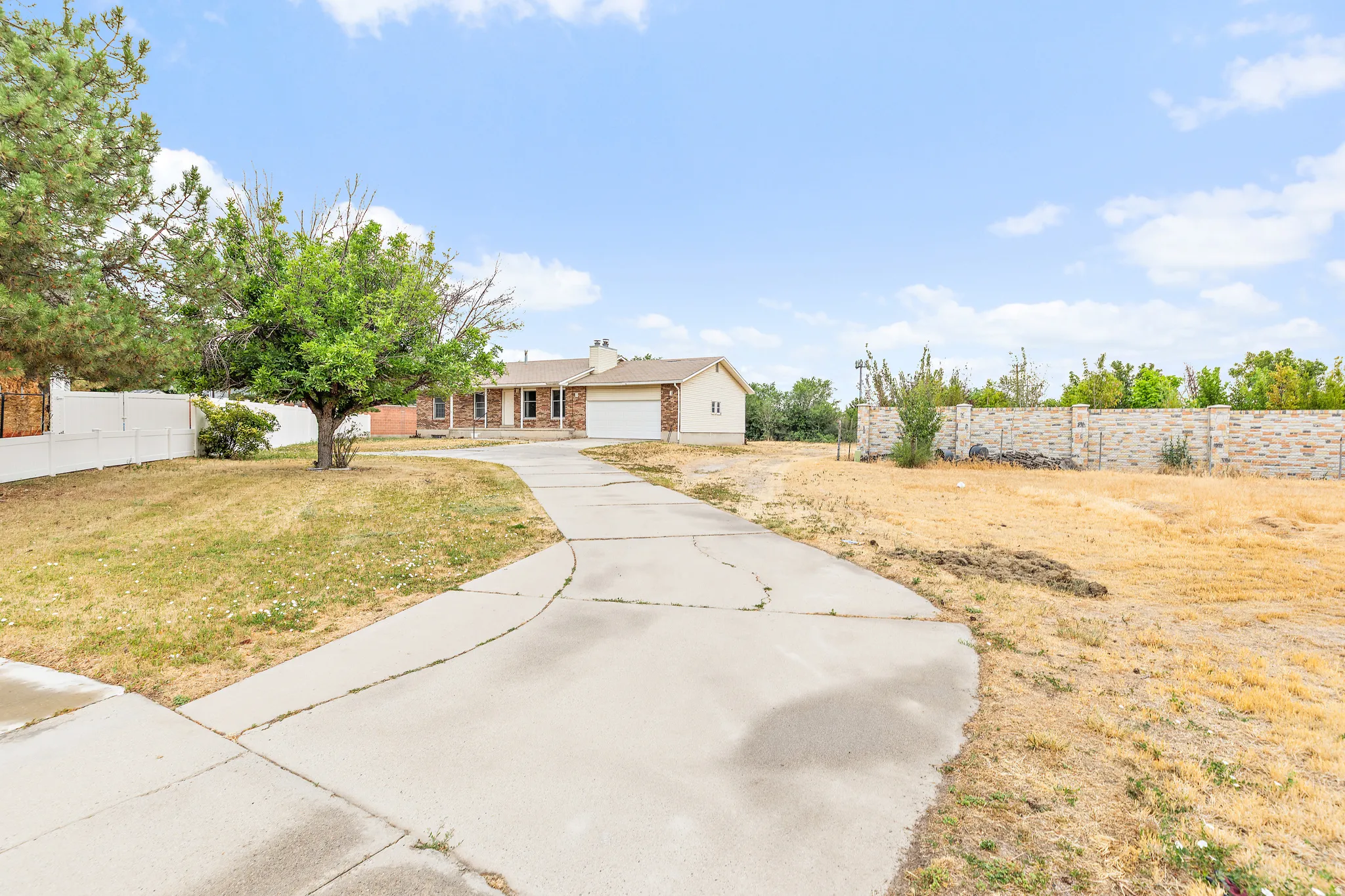 Exterior featuring a brick facade, attached garage, and concrete driveway
