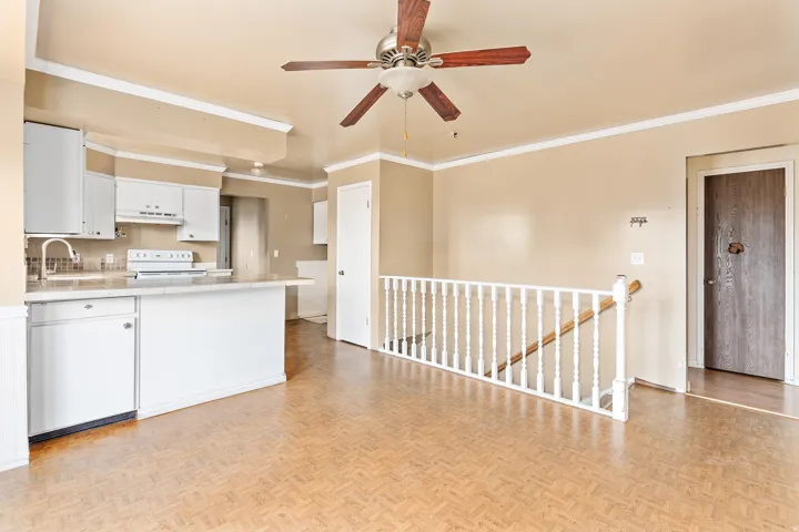 Kitchen with white cabinetry, a built-in dishwasher, and an integrated breakfast bar