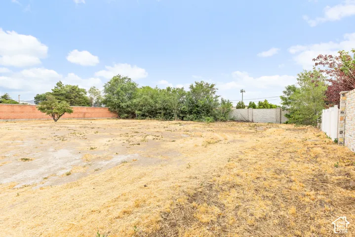 Expansive undeveloped lot with existing perimeter fencing on multiple sides