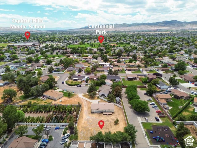 Aerial perspective of a residential lot featuring expansive grounds and a mountain backdrop