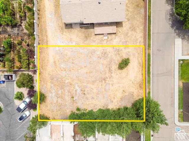 Expansive undeveloped lot featuring clear boundaries, established street access, and surrounding residential structures
