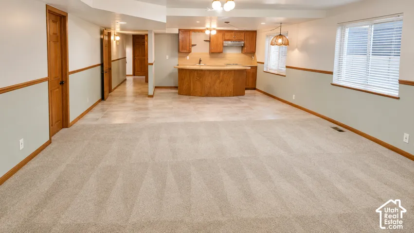 Spacious room with light-colored carpeting, wood-finish doors, and wainscoting