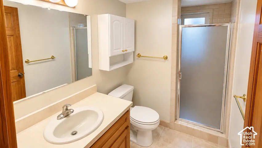 Vanity with integrated sink, wood-finish cabinetry, and laminate countertop
