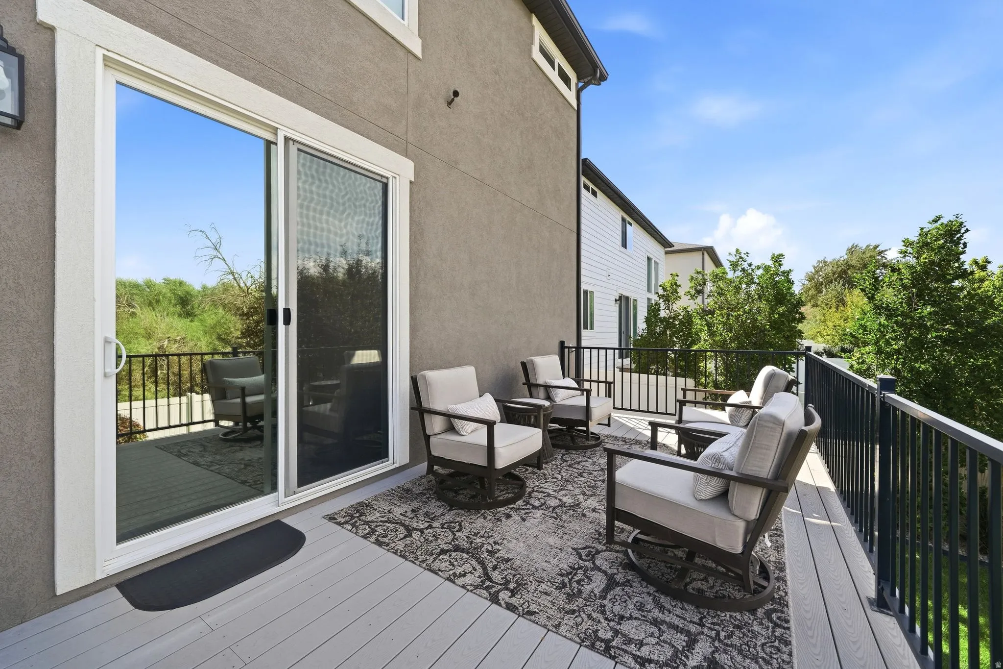 Spacious outdoor deck featuring composite decking and a black metal railing