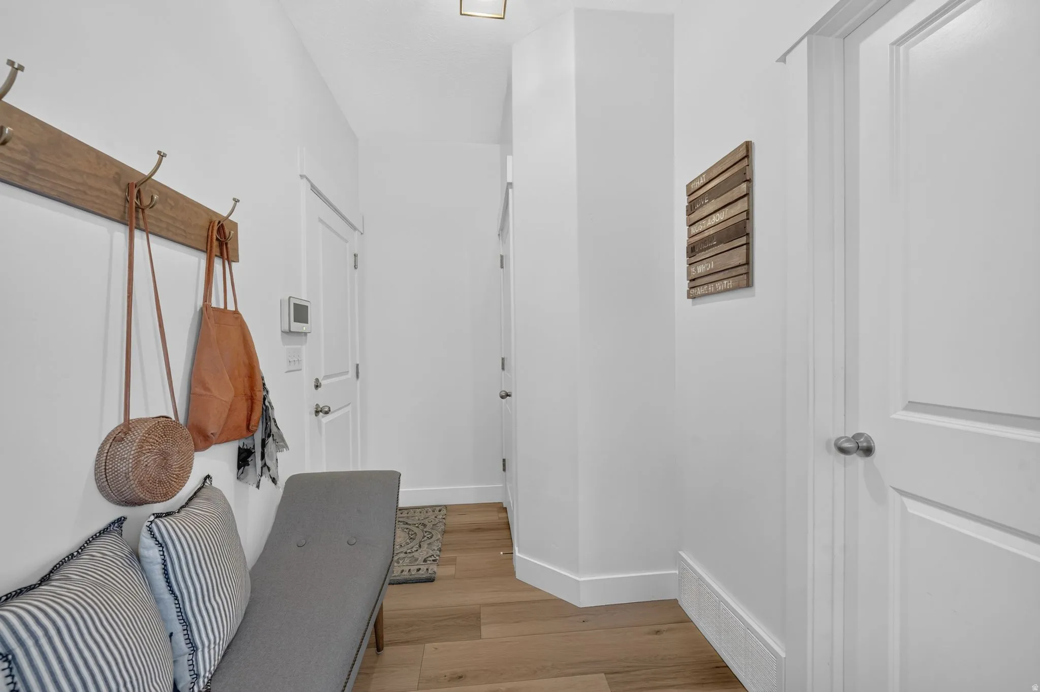 Recessed ceiling lighting, light wood-finish flooring, white painted walls, and white trim molding
