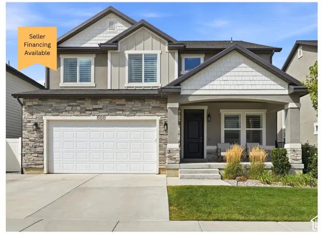 Stone veneer and siding exterior with a covered entry, an attached garage, and a concrete driveway