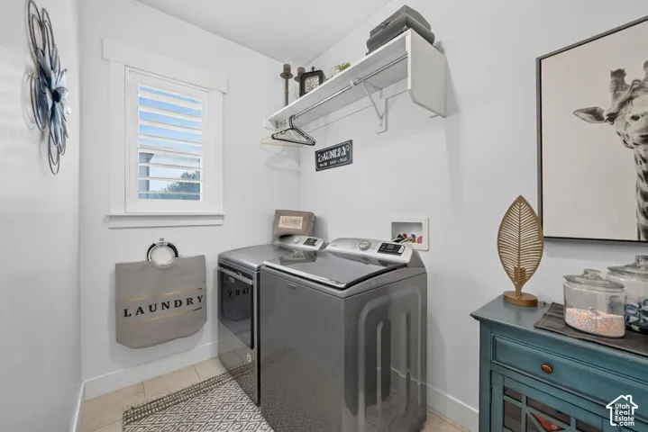 Laundry area featuring a window with white shutters, a built-in shelving unit, and tile flooring