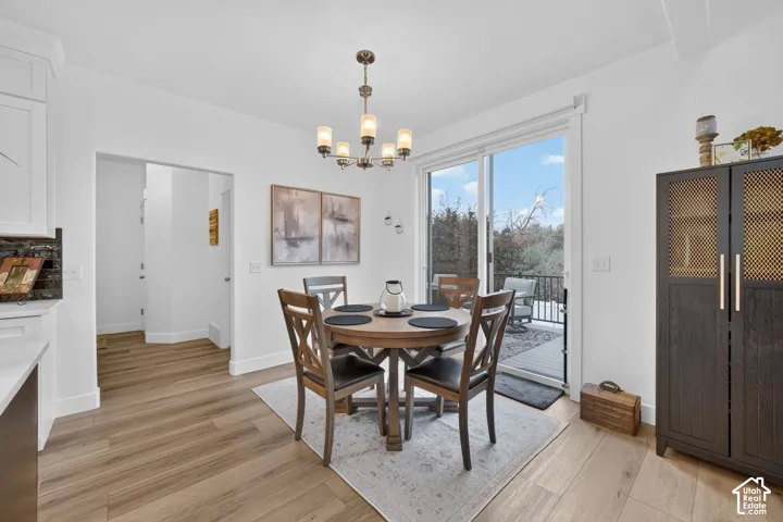 Wood-finish flooring throughout, white walls, and a multi-light chandelier