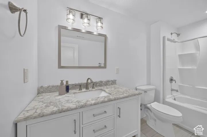 White vanity with brushed nickel hardware, integrated sink, and stone-finish countertop