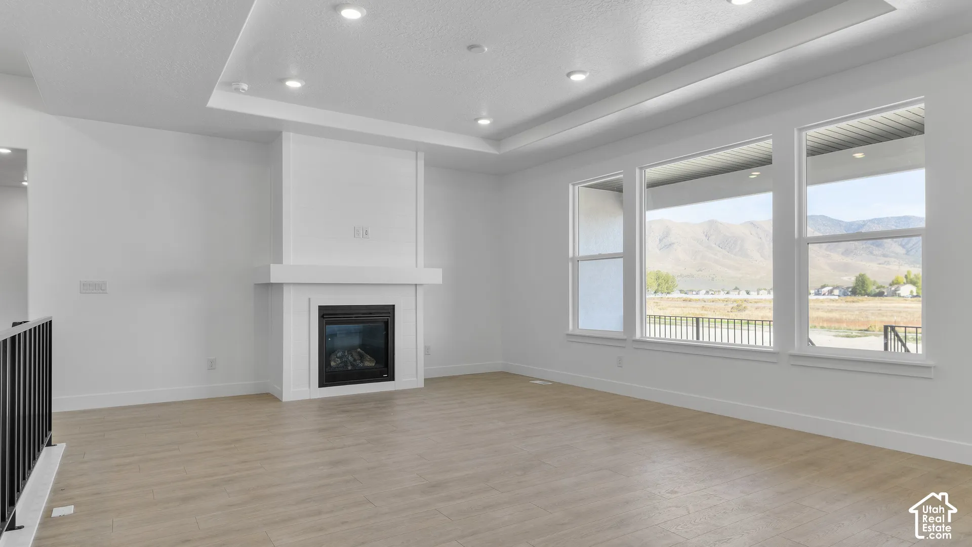 Recessed lighting illuminates the tray ceiling, complementing the natural light from three expansive windows
