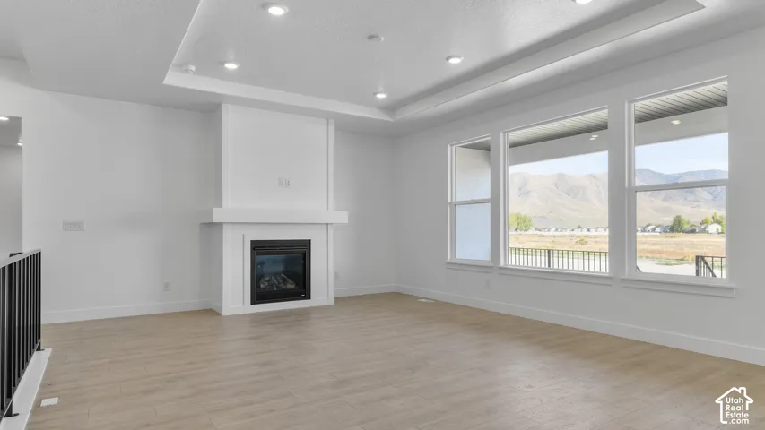 Recessed lighting illuminates the tray ceiling, complementing the natural light from three expansive windows