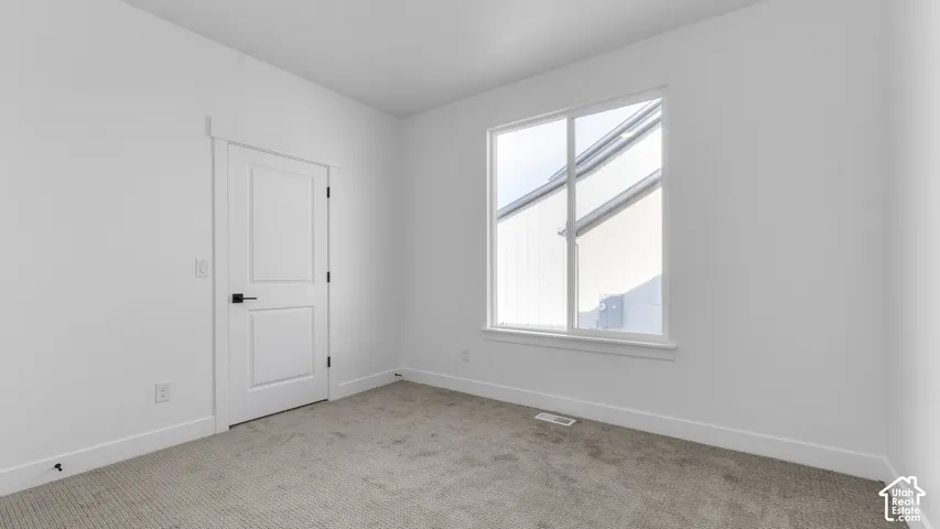 Crisp white walls, neutral carpet, and a two-panel interior door with matte black hardware
