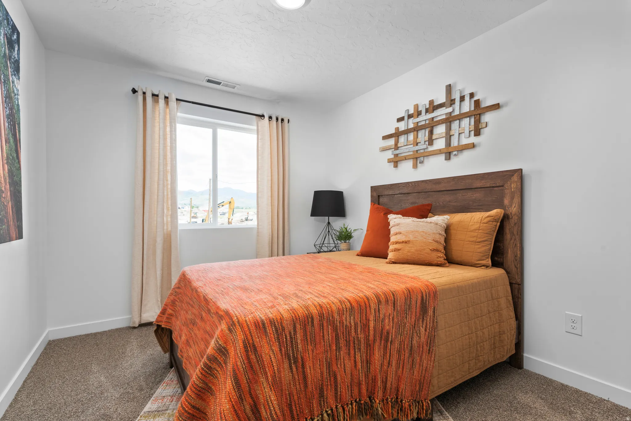 Carpeted bedroom featuring a window with substantial natural light and a built-in wood-finish headboard