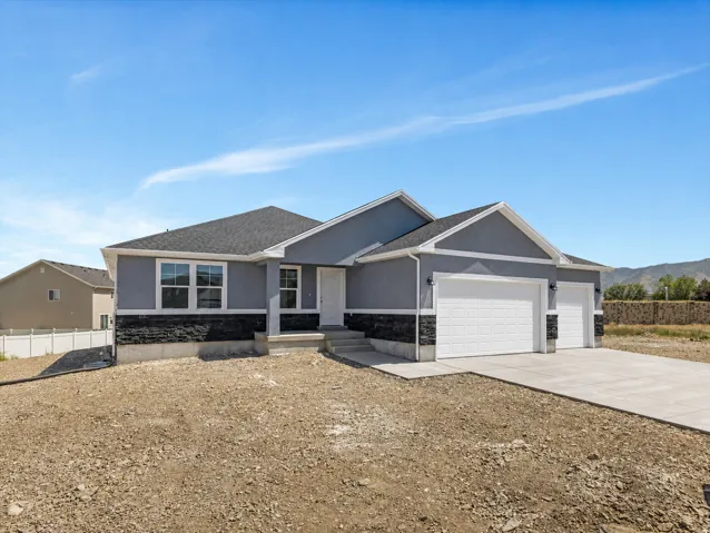 Contemporary exterior with a stucco finish, stone veneer accent, and a gabled roof