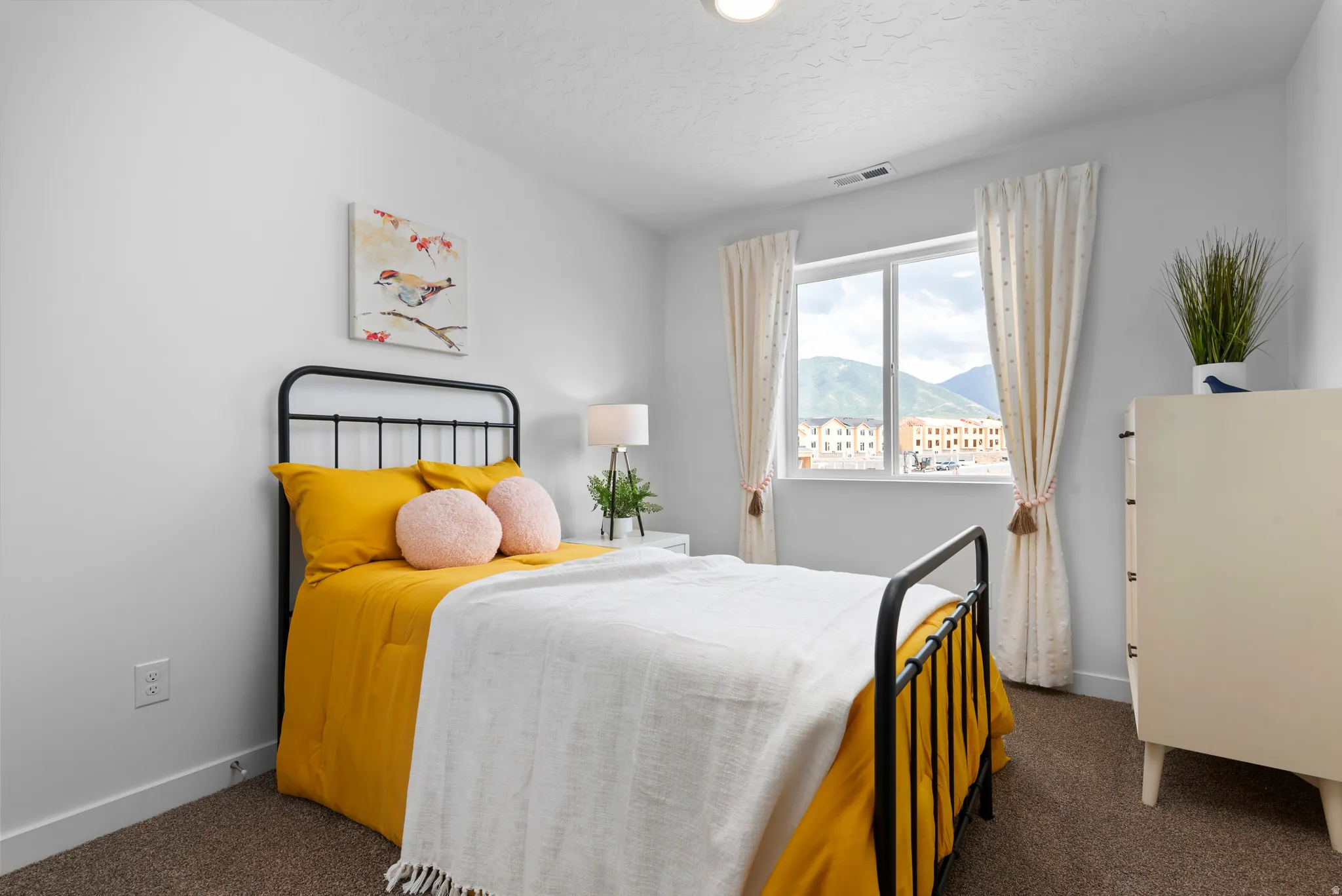 Wall-to-wall carpeting with light-toned walls, featuring a window with a mountain backdrop
