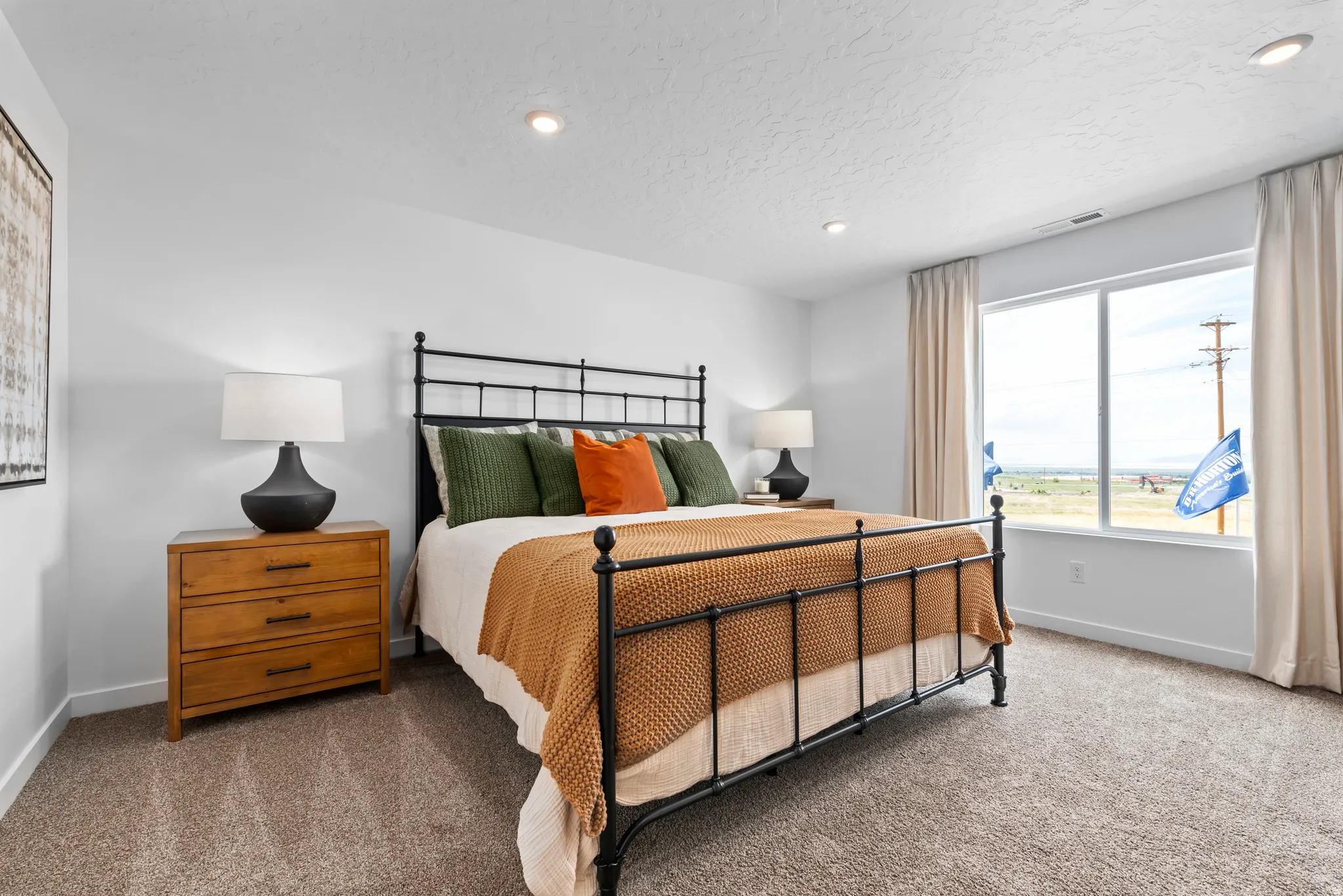 Recessed lighting, large window with drapes, and carpeted flooring