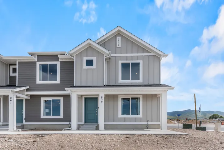 Contemporary duplex exterior featuring a two-tone facade, prominent gables, and an inviting covered porch entry