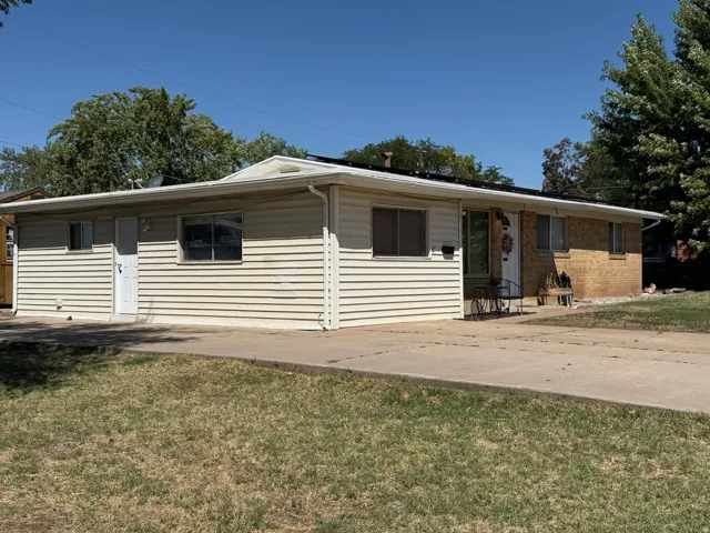 Partial brick and siding exterior with a concrete driveway