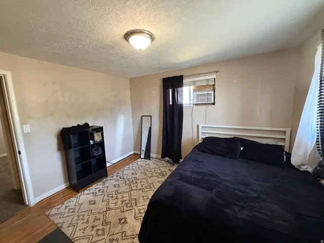 Recessed lighting fixture, wood-finish flooring, and a window with blinds