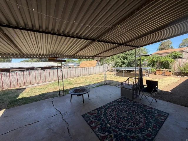 Covered patio area featuring a concrete surface and a corrugated metal roof