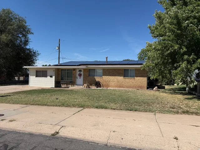 Brick and siding exterior with solar panels and a front lawn