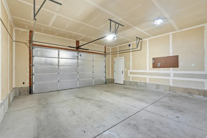 Concrete flooring, overhead garage door system, interior access door, recessed ceiling lighting