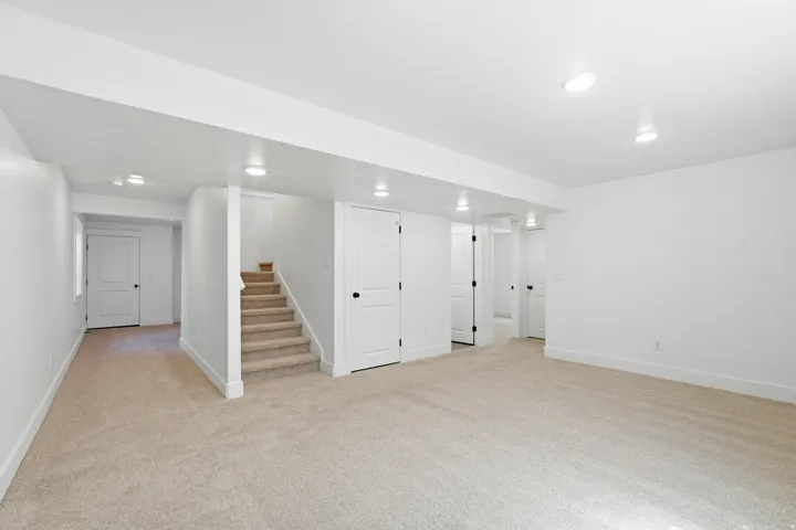 Carpeted floors and stairs, white walls, recessed lighting, and multiple paneled doors