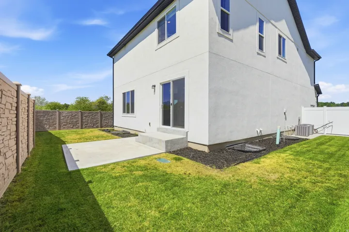 Stucco exterior with multiple windows and a sliding glass door