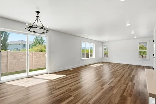 Spacious room featuring wood-finish flooring and multiple windows for abundant natural light