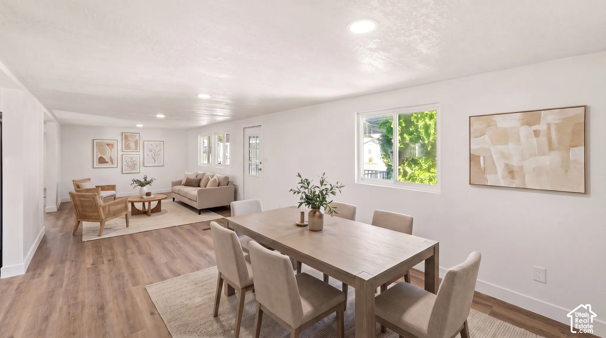 Open-concept living area featuring wood-finish flooring, recessed lighting, and multiple windows