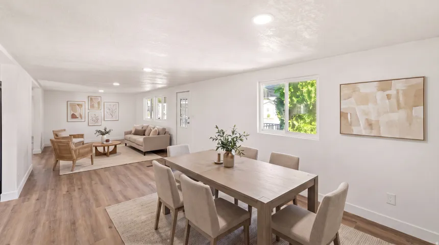 Open-concept living area featuring wood-finish flooring, recessed lighting, and multiple windows