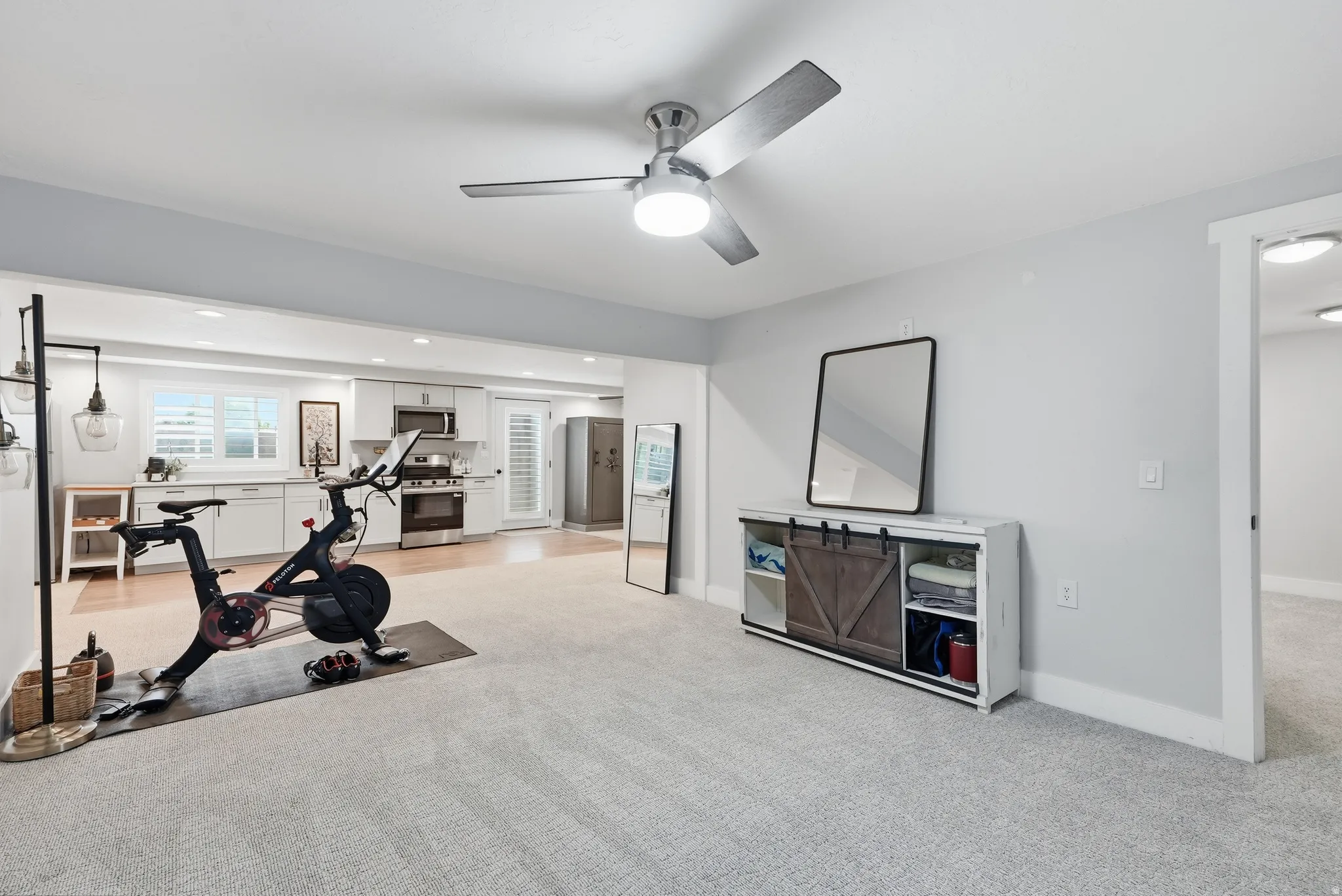 Recessed lighting, wood-finish flooring, white cabinetry, stainless steel appliances, and a ceiling fan with integrated lighting