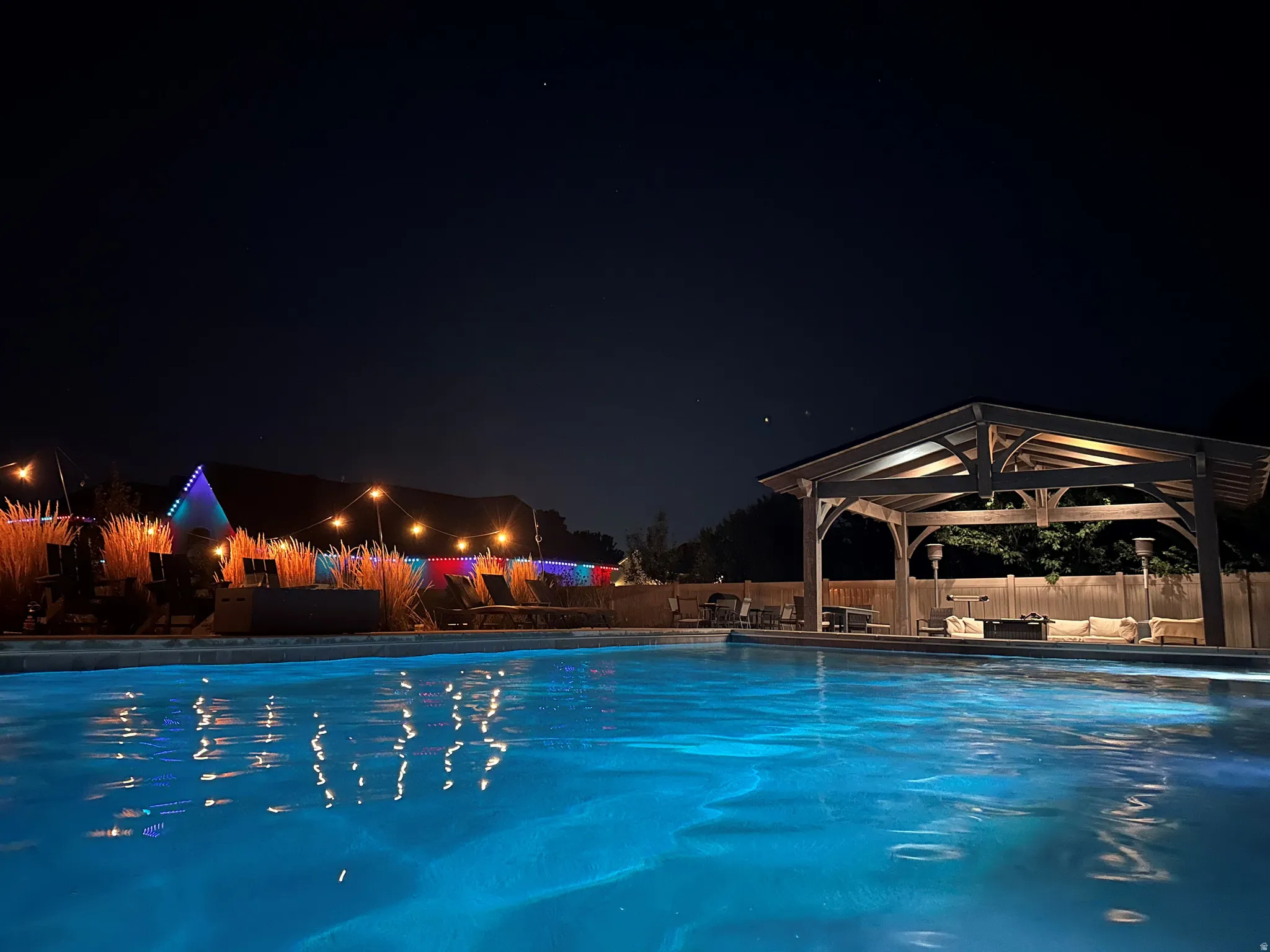 Swimming pool with a wood-frame gazebo and surrounding hardscaping