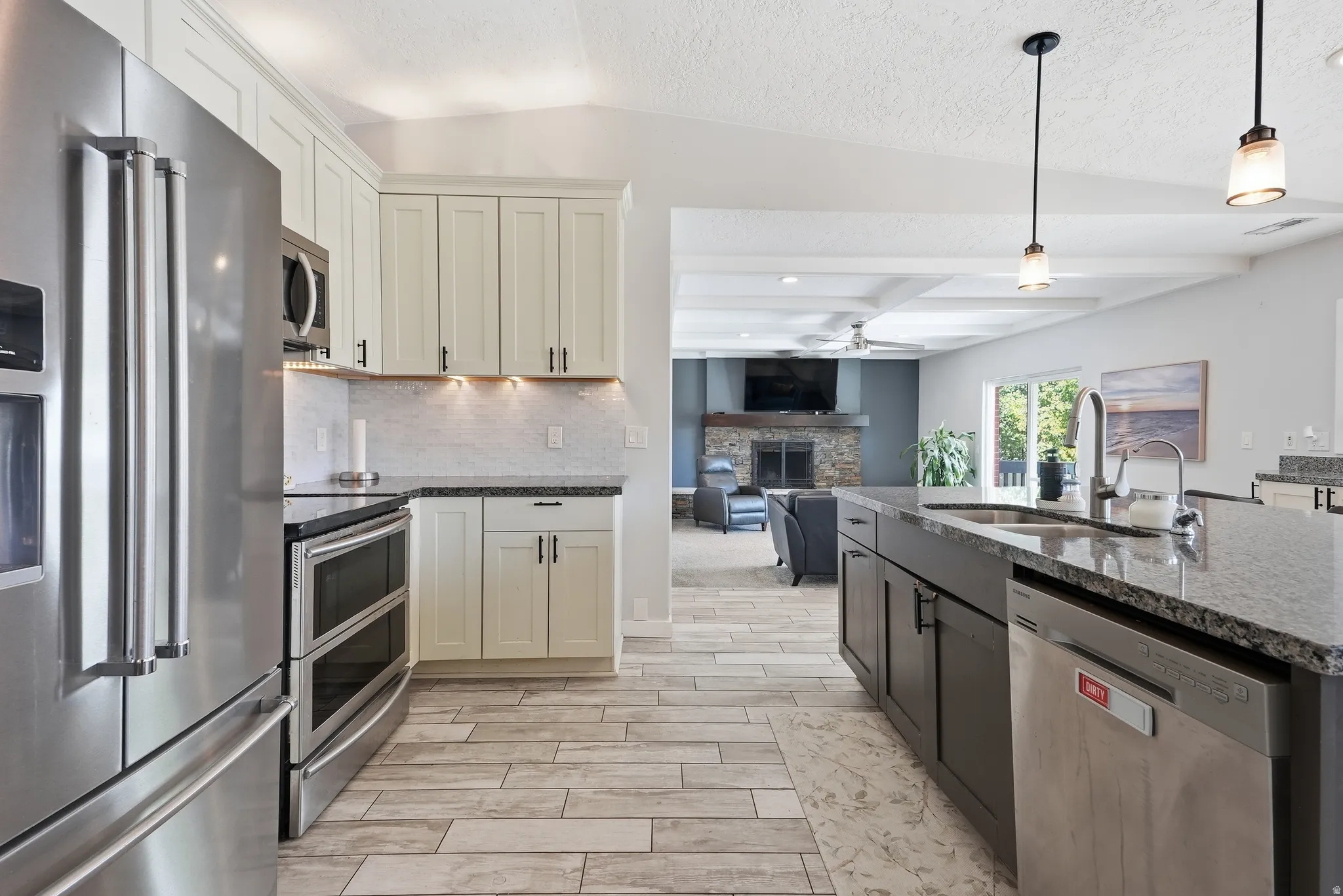 Kitchen featuring stainless steel appliances, wood-finish flooring, recessed lighting, and granite countertops