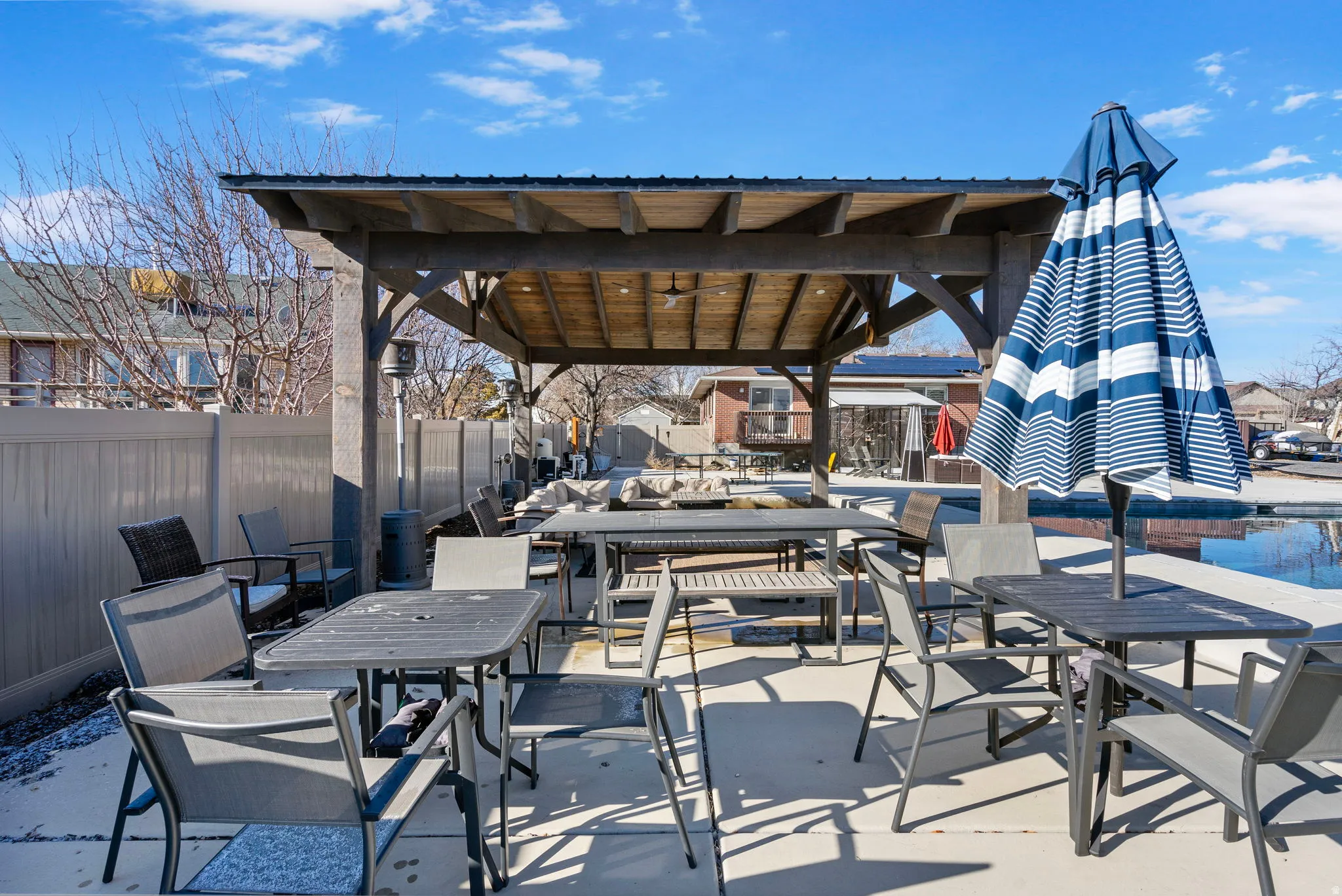 Expansive outdoor patio with a wooden pergola structure and concrete flooring