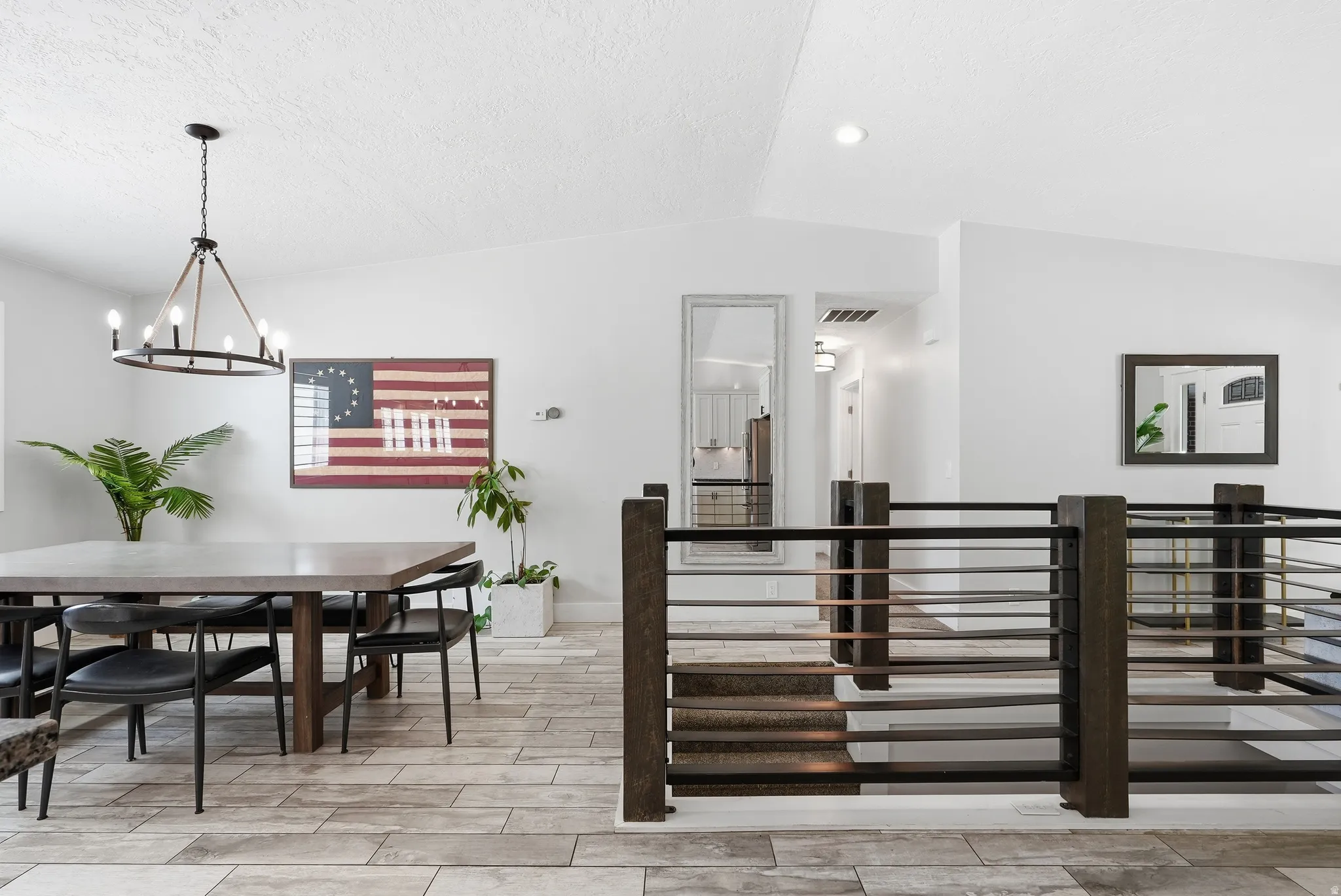 Vaulted ceilings with recessed lighting, tile flooring, and a modern chandelier