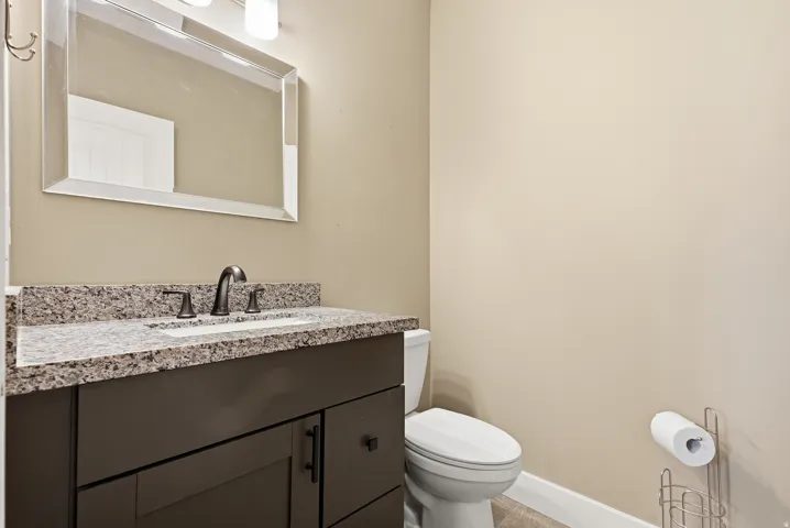 Vanity with a granite countertop, integrated rectangular sink, and oil-rubbed bronze faucet