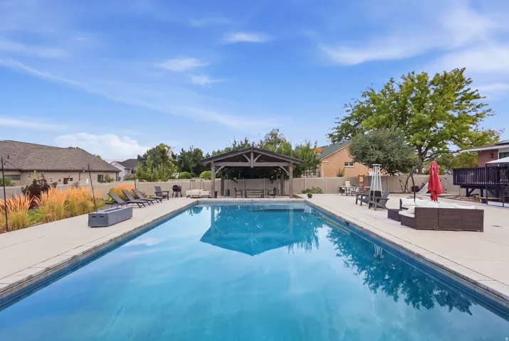 Resort-style saltwater swimming pool with crystal-clear water, flanked by expansive composite decking and mature landscaping