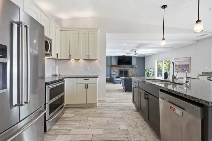 Kitchen featuring stainless steel appliances, wood-finish flooring, recessed lighting, and granite countertops