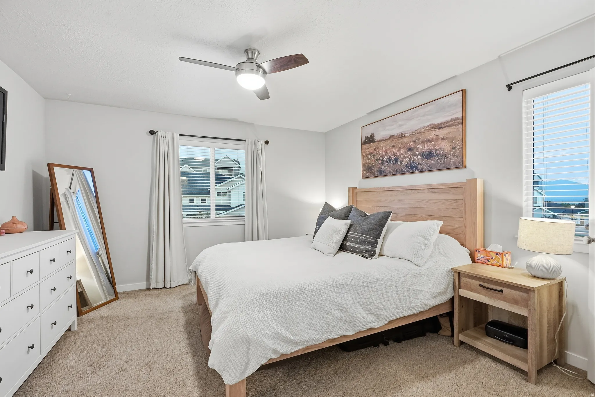 Wall-to-wall carpeting and a ceiling fan with integrated lighting