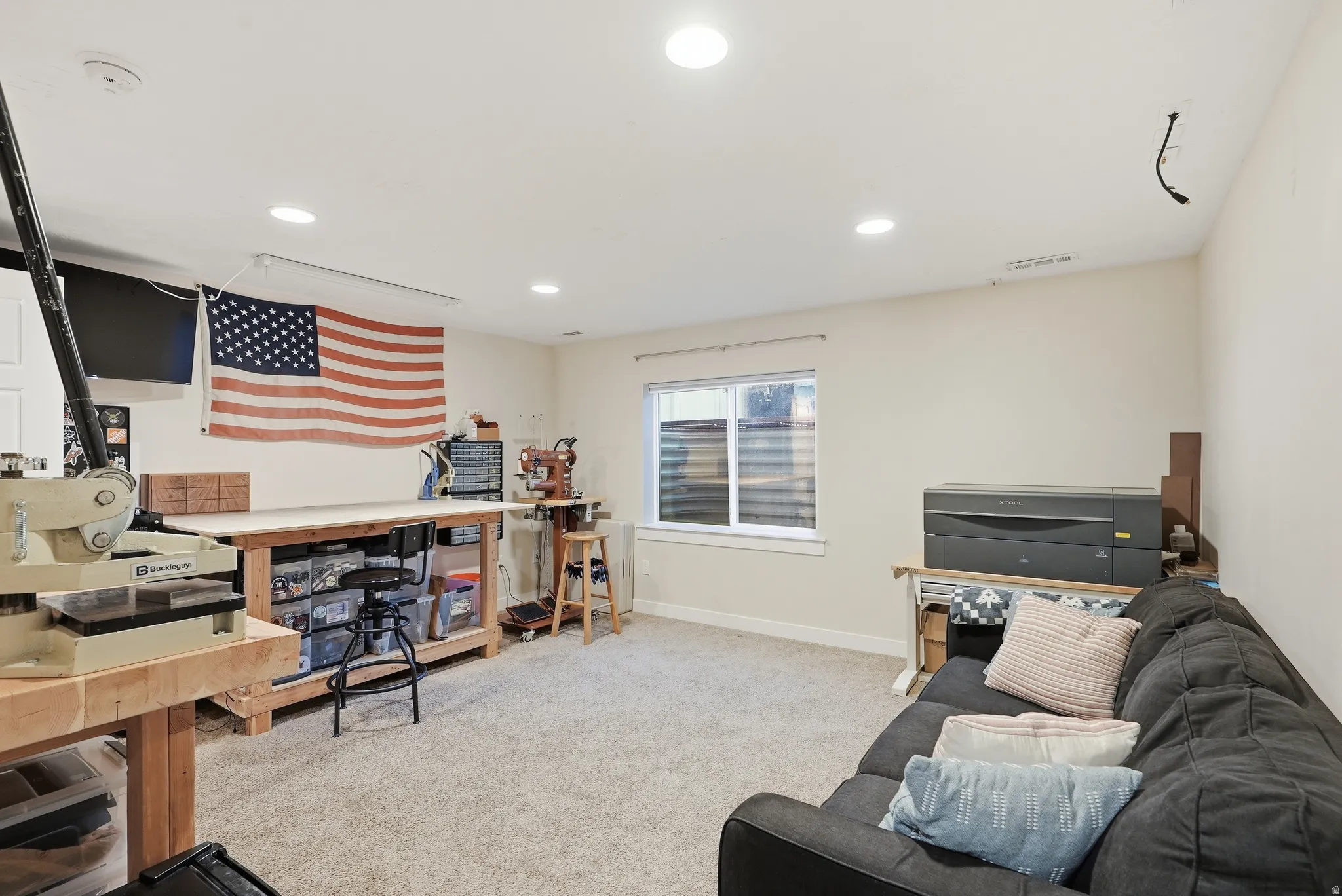 Recessed lighting, light-toned carpeting, and a window with blinds