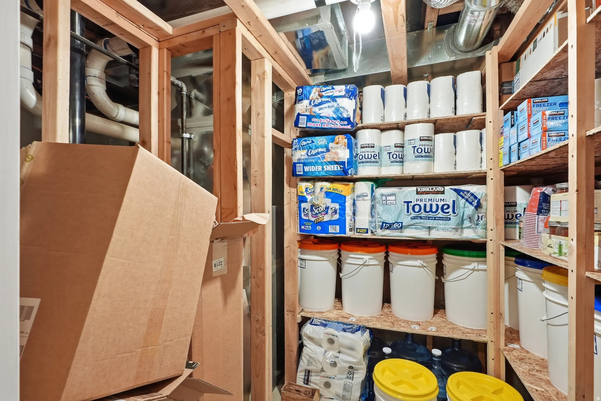 Utility space with exposed wood framing, overhead lighting, and built-in wood shelving