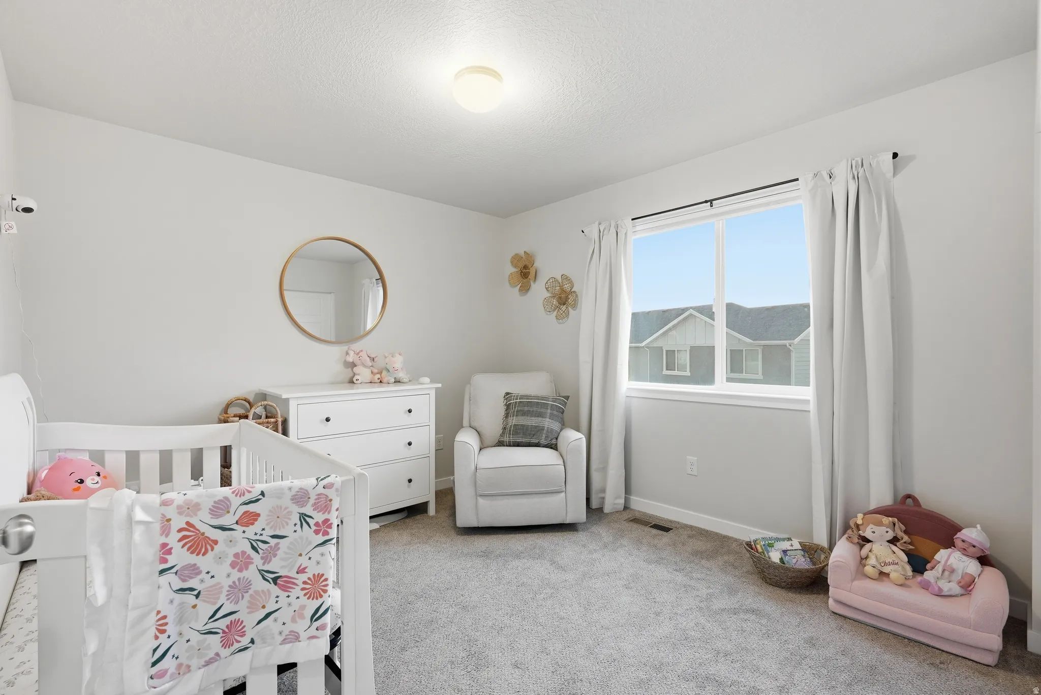 Recessed lighting, light gray carpeting, and a double-pane window with white trim
