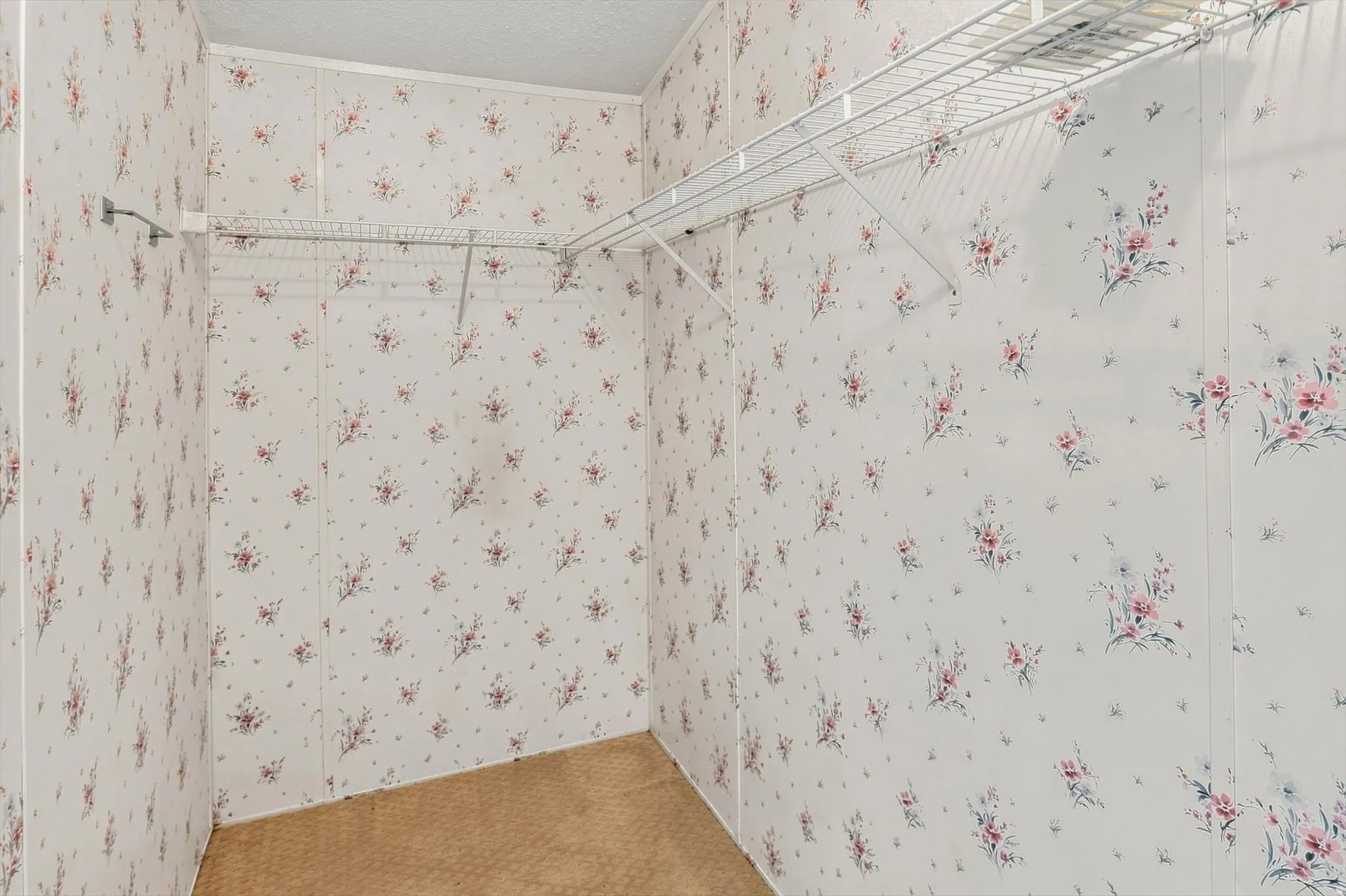 Walk-in closet with wire shelving and hanging rods